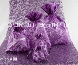 products-IMG_7352-copy שקיות אורגנזה + ספירלה קטיפה: ארבע שקיות סגולות עם דוגמת פרחים בגדלים שונים מוצגות על בד תואם, לצד כיתוב בעברית וספירלת קטיפה לקישוט.