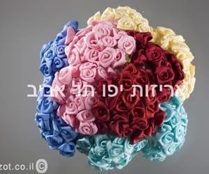 products-IMG_7885-copy זר פרחי בד ונייר עם חוט מתכת בגוונים עזים של ורוד, אדום, צהוב, כחול וטורקיז מסודרים במעגל. טקסט עברי לבן מונח על גבי התמונה.