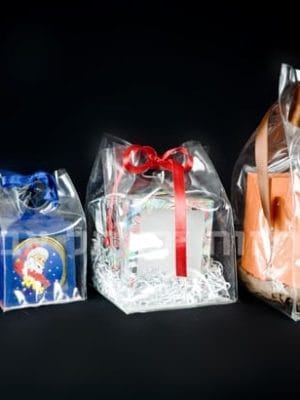 products-IMG_7239 ארבע שקיות פלסטיק קשיחות עם בסיס בגדלים שונים, כל אחת עם סרט צבעוני, מציגות קישוט, קופסה עם סנטה, ספל מעוטר וקופסה כתומה—הכל על רקע שחור.